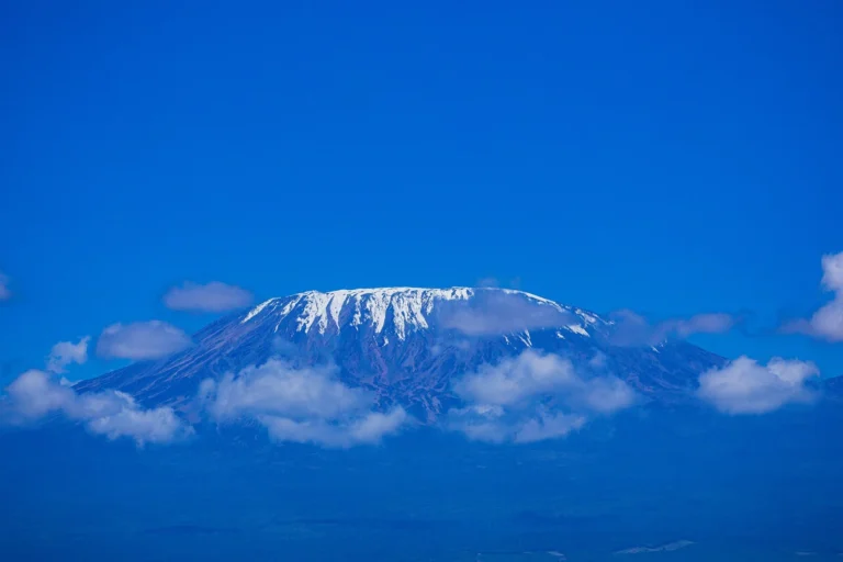 The snow-covered Kibo summit of Mount Kilimanjaro seen above clouds